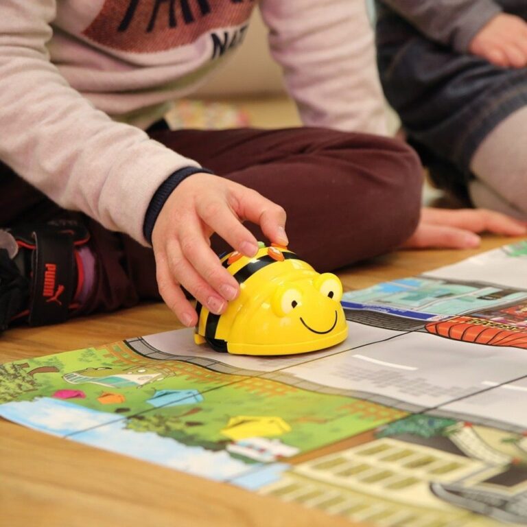 Child plays with Bee-bot on colourful mat